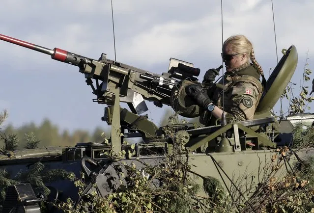 A Danish Army soldier takes off her helmet during a break in the "Silver Arrow 2015" NATO military exercise, at a training field near Adazi, Latvia, September 27, 2015. Approximately 2,400 personnel from six nations are participating, said Latvia's Ministry of Defence. (Photo by Ints Kalnins/Reuters)