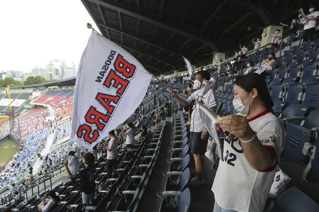 Fans wearing face masks to help protect against the spread of the new coronavirus watch the KBO league game between Doosan Bears and LG Twins in Seoul, South Korea, Sunday, July 27, 2020. Masked fans hopped, sang and shouted cheering slogans in baseball stadiums in South Korea on Sunday as authorities began bringing back spectators in professional sports games amid the coronavirus pandemic. (Photo by Ahn Young-joon/AP Photo)