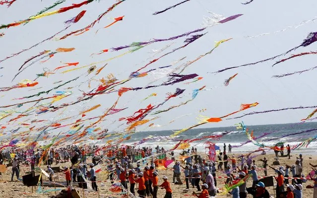 Thousands of children fly kites in an attempt to break the world record for the number of kites flown at the same time, in the town of Beit Lahiya, northern Gaza Strip, Thursday, July 29, 2010. More than 7,200 kites were raised in the air on Thursday, setting a new world record in an event sponsored by the United Nations. (Photo by Khalil Hamra/Associated Press)