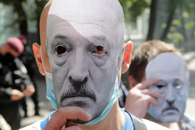 Participants hold paper masks depicting Belarusian President Alexander Lukashenko during a rally to support the opposition of Belarus in front of the Belarusian embassy in Kyiv, Ukraine on August 14, 2020. (Photo by Valentyn Ogirenko/Reuters)