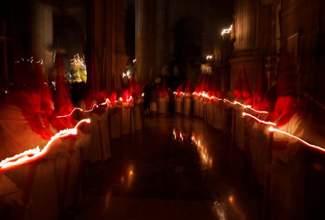 Penitents hold candles as they take part in a penitence act inside a church after the governing body of Silencio brotherhood decided that penance could not be carried out in the streets due to the heavy rain of the Nelson storm during the Holy Week in Ronda, Spain on March 27, 2024. (Photo by Jon Nazca/Reuters)
