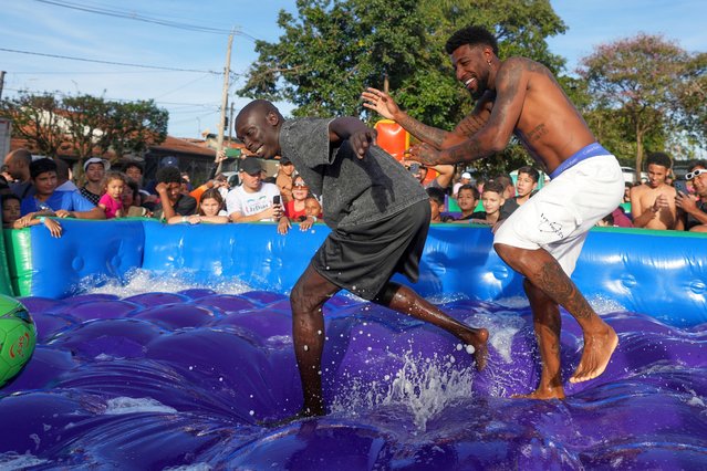 TikTok personality Khaby Lame, left center, and Brazilian soccer player Emerson Royal, play soccer on a inflatable pool during an event to donate toys to children in Americana, Brazil, June 13, 2025. (Photo by Andre Penner/AP Photo)