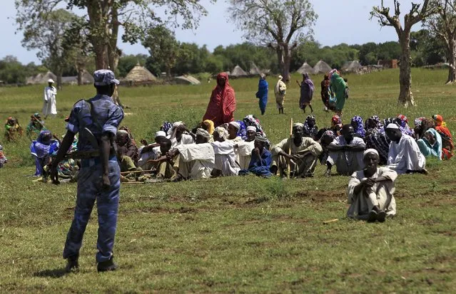 Displaced people gather to receive food provided by the United Nations' World Food Programme (WFP) during a visit by a European Union delegation, at an Internally Displaced Persons (IDP) camp in Azaza, east of Ad Damazin, capital of Blue Nile state, Sudan October 21, 2015. (Photo by Mohamed Nureldin Abdallah/Reuters)