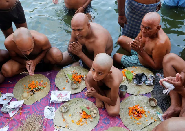 Hindu devotees pray after taking a dip in a holy pond to honour the souls of their departed ancestors on the auspicious day of Mahalaya, which is also called Shraadh or Pitru Paksha, in Mumbai, India, September 30, 2016. (Photo by Shailesh Andrade/Reuters)