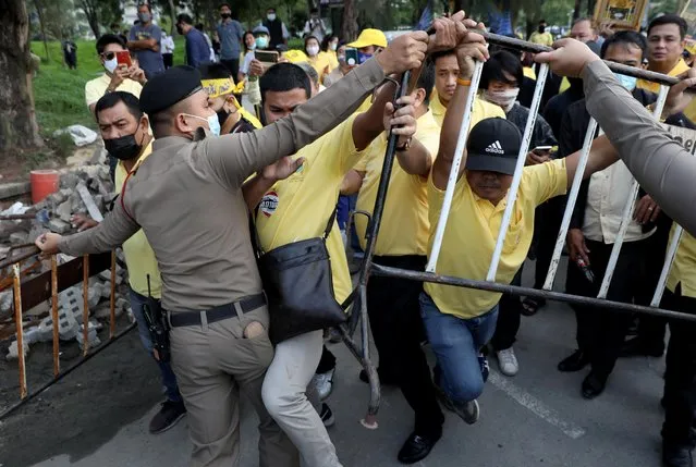 Police try to separate pro-democracy protesters and royalists (wearing yellow) during a clash in Bangkok, Thailand on October 21, 2020. (Photo by Soe Zeya Tun/Reuters)