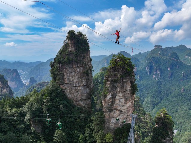 This drone photo taken on Aug. 18, 2025 shows Stijn of Belgium competing during the 2025 “Slackline King” Championship at Huangshizhai scenic spot in Zhangjiajie, central China's Hunan Province. Some 20 elite slackline athletes from China, France, Brazil, and other countries and regions competed in the event. (Photo by Xinhua News Agency/Rex Features/Shutterstock)