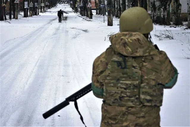 A Ukrainian soldier patrols the street in Bakhmut, Donetsk region, Ukraine, Tuesday, February 14, 2023. (Photo by Libkos/AP Photo)