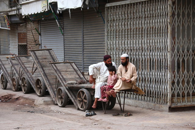 People rest at a closed market during a shutter-down strike, in Karachi, Pakistan, 19 July 2025. Businesses across Karachi on 19 July observe a strike, backed by dozens of trade bodies, in protest against new tax provisions in Pakistan's new Finance Act, with the Karachi Chamber of Commerce and Industry (KCCI) leading the call. (Photo by Rehan Khan/EPA)