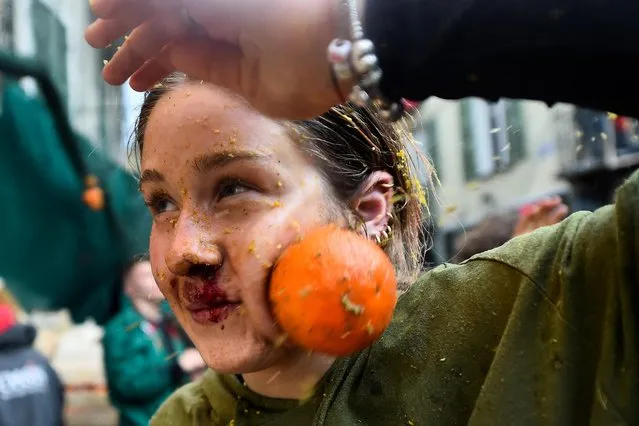 A reveller is hit by an orange as she participates in the annual “Battle of the Oranges” in the northern city of Ivrea, Italy on February 19, 2023. (Photo by Massimo Pinca/Reuters)