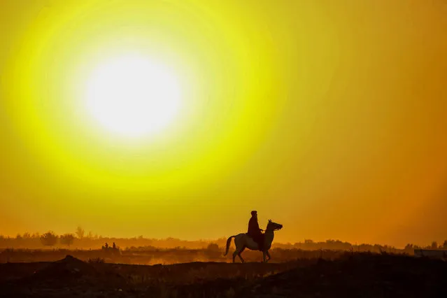 A man rides a horse at sunset near the Pashtoon Pul in Injil district of Herat province on October 7, 2020. (Photo by Hoshang Hashimi/AFP Photo)
