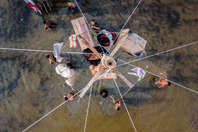 A participant climbs a greasy pole to reach prizes during a traditional game called Panjat Pinang during celebrations to mark Indonesia's 80th Independence Day on Sunday, August 17, 2025, on the outskirts of Banda Aceh, Indonesia. (Photo by Chaideer Mahyuddin/AFP Photo)
