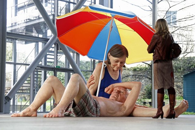 A visitor looks at a sculpture entitled “Couple Under an Umbrella, 2013” by artist Ron Mueck during the press day for his exhibition at the Fondation Cartier pour l'art contemporain in Paris April 15, 2013. (Photo by Charles Platiau/Reuters)