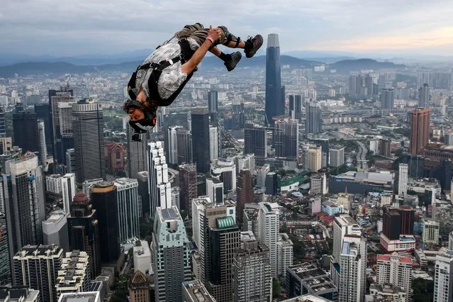 A BASE (Building, Antenna, Span and Earth) jumper in action above Kuala Lumpur skyline during the Kuala Lumpur BASE jump event in Kuala Lumpur, Malaysia 03 February 2023. More than 100 BASE jumpers took part in the extreme sport event. (Photo by Fazry Ismail/EPA/EFE/Rex Features/Shutterstock)