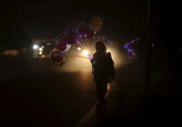 A street vendor sells colorful balloons ahead of Christmas in Jammu, India, Tuesday, December 22, 2020. Though Hindus and Muslims comprise a majority of the population in India, Christmas is a national holiday celebrated with much fanfare. (Photo by Channi Anand/AP Photo)