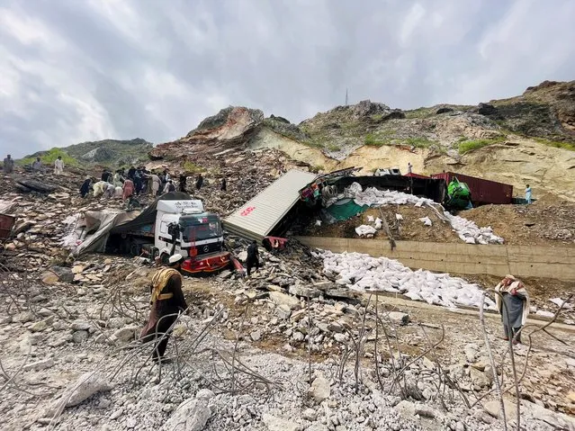 A view of trucks loaded with supplies are seen trapped in a landslide on the road close to the Torkham border, Pakistan on April 18, 2023. (Photo by Fayaz Aziz/Reuters)