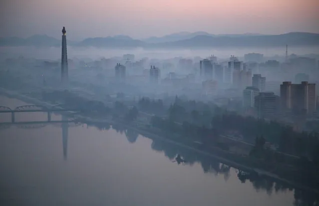 Dawn breaks over Pyongyang, North Korea, as buildings poke through the midst and the Juche Tower, left, stands by the Taedong riverbank on Tuesday, October 13, 2015. (Photo by Wong Maye-E/AP Photo)