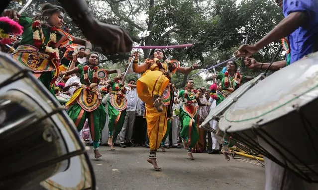 Tribal artists and supporters from the southern Indian state of Karnataka dance outside the residence of Congress Party President Sonia Gandhi during her birthday celebrations in New Delhi, India, December 9, 2015. (Photo by Altaf Qadri/AP Photo)