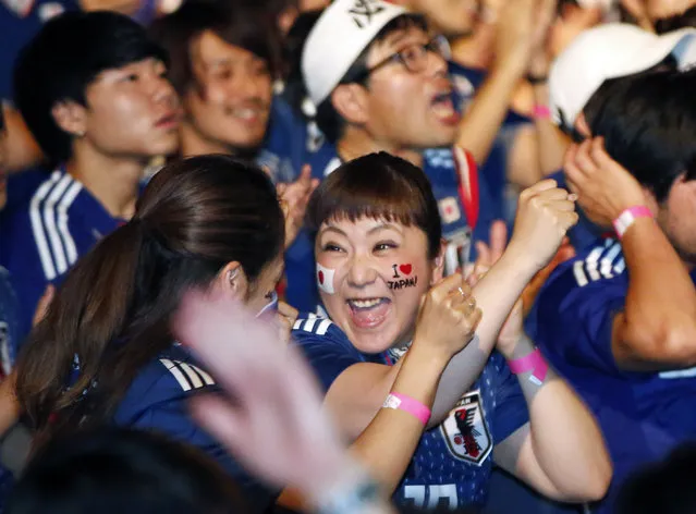 Japanese soccer fans celebrate at a public viewing venue in Tokyo, Thursday, June 28, 2018, as Japan advanced to the next stage of the World Cup following their team's loss to Poland in the Group H World Cup soccer match. (Photo by Shuji Kajiyama/AP Photo)
