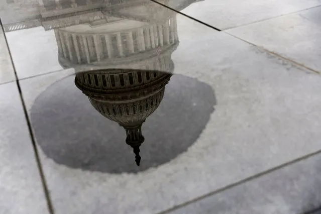 The U.S. Capitol's dome is reflected in a puddle, in the midst of an ongoing legislative effort to raise the United States' debt ceiling and avoid a catastrophic default, in Washington, U.S. May 30, 2023. (Photo by Jonathan Ernst/Reuters)