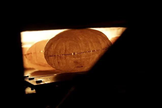 Bread is baked in an oven at a bakery in the rebel-controlled area of Maaret al-Numan town in Idlib province, Syria December 17, 2015. (Photo by Khalil Ashawi/Reuters)