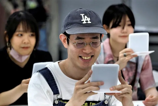 Students practice smiling at a smile training course at Sokei Art School in Tokyo, Japan on May 30, 2023. (Photo by Kim Kyung-Hoon/Reuters)