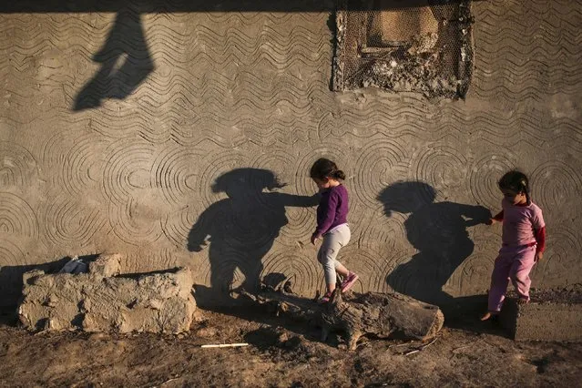 The shadows of children cast on the wall of their home in the Nile Delta town of Behira, 300 kilometers (186 miles) north of Cairo, Egypt, Wednesday, May 6, 2015. (Photo by Mosa'ab Elshamy/AP Photo)