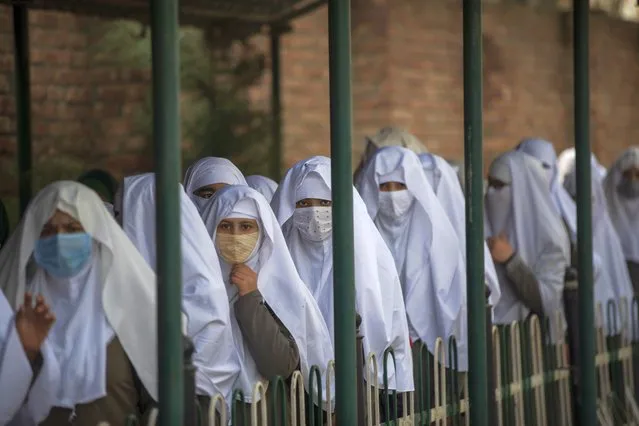 Kashmiri students wearing face masks arrive to attend a school in Srinagar, Indian controlled Kashmir, Monday, March 15, 2021. Schools reopened for the lower grades Monday in Indian-controlled Kashmir, eleven months after being closed due to the coronavirus pandemic. (Photo by Mukhtar Khan/AP Photo)