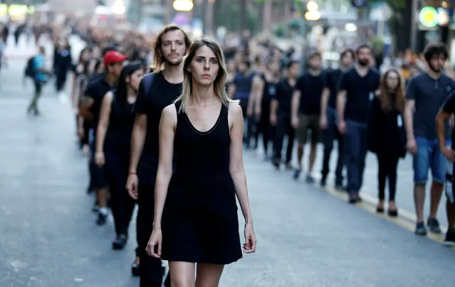 People participate in a demonstration organized by “Mujeres de Negro” (women in black) to protest against gender violence in Montevideo, November 25, 2016. (Photo by Andres Stapff/Reuters)