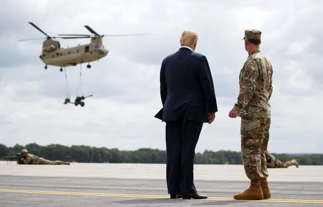 President Donald Trump and Maj. Gen. Walter Piatt view air assault exercises at Fort Drum, N.Y., Monday, August 13, 2018, before a signing ceremony for a $716 billion defense policy bill named for Sen. John McCain. (Photo by Carolyn Kaster/AP Photo)