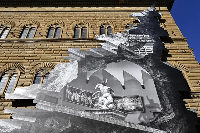 A general view shows visual installation “La Ferita” (The Wound) by French artist JR after its unveiling on the facade of the Renaissance Palazzo Strozzi in Florence on March 19, 2021. JR has reinterpreted the façade of the Renaissance palazzo with one of his signature optical illusions, appearing to open up the building to reveal a vision of an interior at once real and imaginary achieved with a black and white photographic collage to trigger a debate on the accessibility of culture in the age of Covid-19. (Photo by Alberto Pizzoli/AFP Photo)