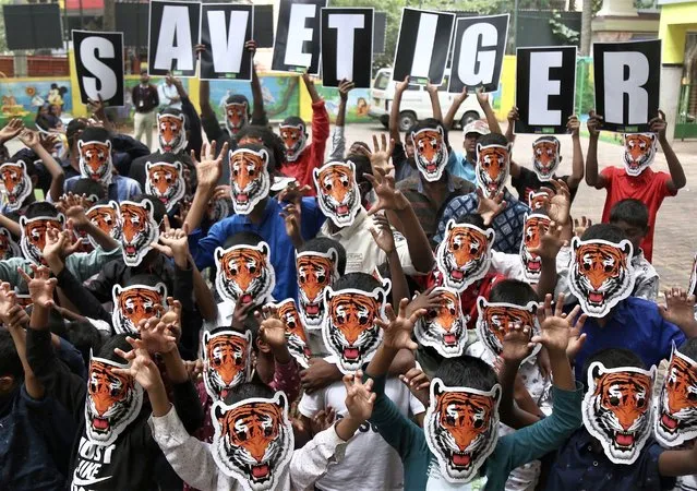 Underprivileged children supported by the international Don Bosco organization in India wear tiger masks while participating participate in the “Save Our Tiger” awareness campaign on the “International Tiger Day” in Bangalore, India, 29 July 2022. The “International Tiger Day” is observed annually on 29 July to raise awareness about the danger of an extinction of tigers and the need to save them. (Photo by Jagadeesh N.V./EPA)