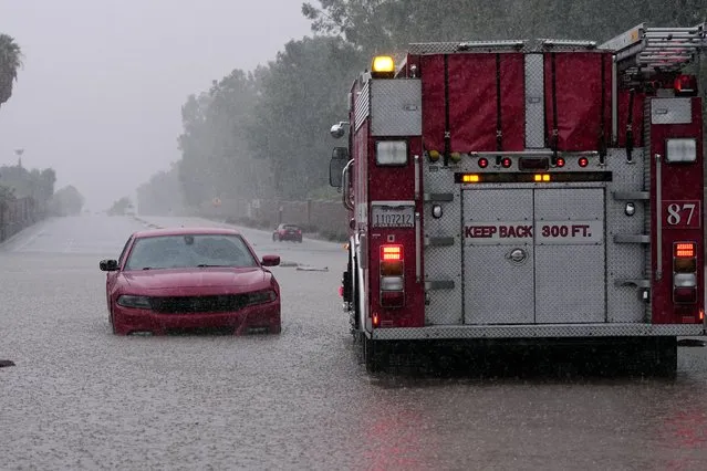 A fire truck pulls away after a motorist became stranded in rising floodwaters caused by torrential rain brought by Tropical Storm Hilary, Sunday, August 20, 2023, in Palm Desert, Calif. (Photo by Mark J. Terrill/AP Photo)