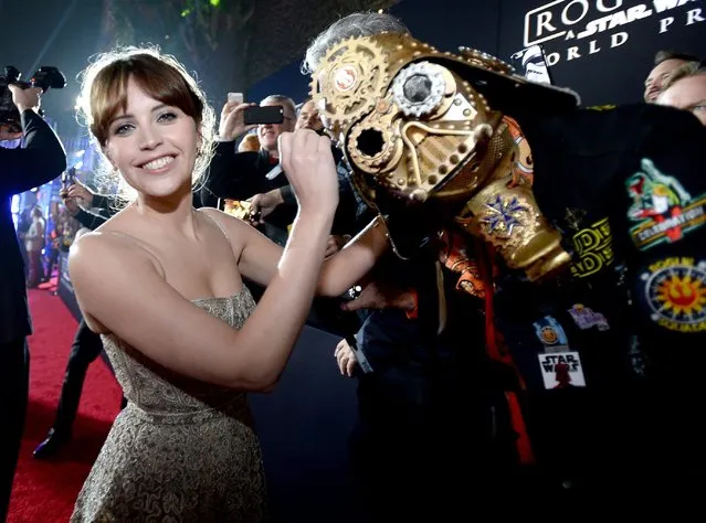 Actress Felicity Jones (L) signs Christopher 'Dude Vader' Canole's helmet at The World Premiere of Lucasfilm's highly anticipated, first-ever, standalone Star Wars adventure, 'Rogue One: A Star Wars Story' at the Pantages Theatre on December 10, 2016 in Hollywood, California. (Photo by Charley Gallay/Getty Images for Disney)