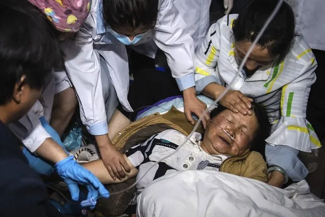 In this photo released by China's Xinhua News Agency, medical workers treat a woman after an earthquake in Yangbi Yi Autonomous County in southwestern China's Yunnan Province, early Saturday, May 22, 2021. A pair of strong earthquakes struck two provinces in China overnight on Saturday. (Photo by Hu Chao/Xinhua via AP Photo)