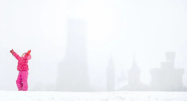 The Smithsonian Institution Building, known as The Castle, is visible behind Mia Molnar, 6, of Tampa, Fla., who plays in the snow on the National Mall in Washington, Thursday, March 5, 2015. The U.S. federal government said its offices in the Washington area will be closed Thursday because of a new round of winter weather expected in the region. The Office of Personnel Management said non-emergency personnel in and around Washington were granted excused absences for the day. Emergency employees and telework-ready employees were expected to work. (AP Photo/Andrew Harnik)