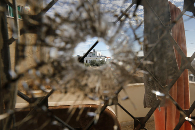 A nearby house is pictured through a bullet hole in a window inside a building that was the site of clashes between Jordanian police and Islamist militant gunmen in the village of Garifla, in Karak, Jordan, December 21, 2016. (Photo by Muhammad Hamed/Reuters)