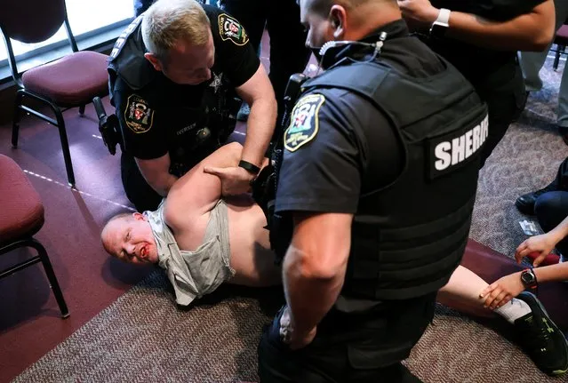 A man is detained after a fight broke out during a Loudoun County School Board meeting which included a discussion of Critical Race Theory and transgender students, in Ashburn, Virginia, U.S. June 22, 2021. (Photo by Evelyn Hockstein/Reuters)