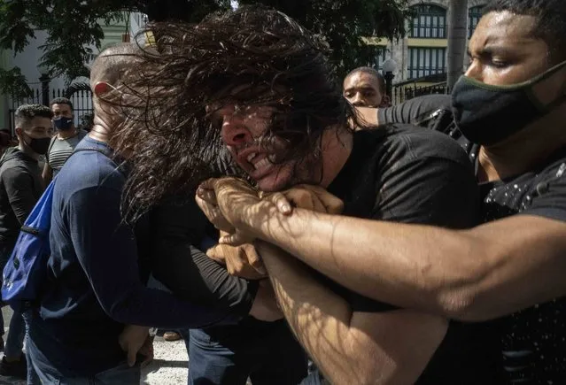 Plainclothes police detain an anti-government protester during a protest in Havana, Cuba, Sunday, July 11, 2021. Hundreds of demonstrators went out to the streets in several cities in Cuba to protest against ongoing food shortages and high prices of foodstuffs, amid the new coronavirus crisis. (Photo by Ramon Espinosa/AP Photo)