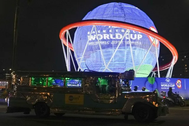 A vehicle passes by a giant FIBA Basketball World Cup themed display near one of the venues at the Mall of Asia Arena on Thursday, August 17, 2023, in Pasay city Philippines. Basketball's World Cup starts on Friday, Aug. 25, spread out over three nations – the Philippines, Japan and Indonesia. It'll be centered in Manila. (Photo by Aaron Favila/AP Photo)