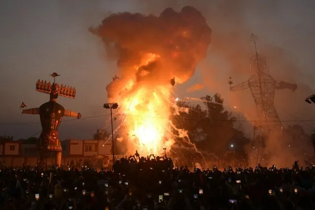 People watch the effigies of Hindu demon Ravana (C), his son Meghnath (L), and brother Kumbhkaran (R) burn on the occasion of the Hindu festival of “Dussehra” in Amritsar on October 24, 2023. (Photo by AFP Photo/Stringer)