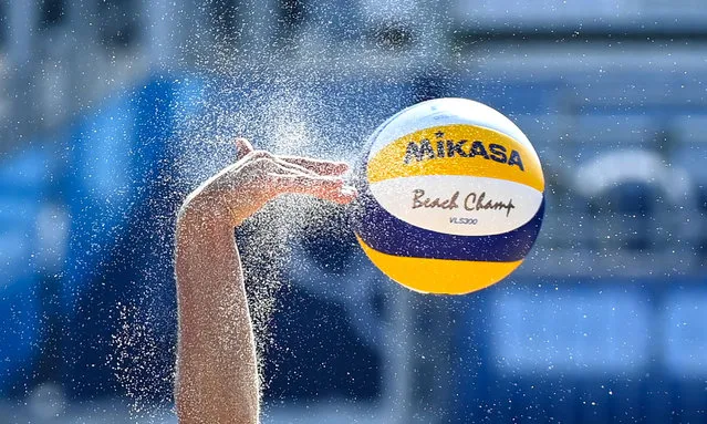 Sand flies off the ball as Italy's Marta Menegatti hits a shot in their women's preliminary beach volleyball pool E match between Russia and Italy during the Tokyo 2020 Olympic Games at Shiokaze Park in Tokyo on July 25, 2021. (Photo by Angela Weiss/AFP Photo)