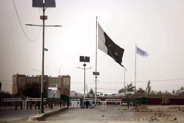 A Flag of Afghan Taliban (in White) is raised at the Afghan side of the Pakistani-Afghan border at Chaman, Pakistan, 14 July 2021. Taliban fighters have captured a vital border crossing with Pakistan at Spin Boldak, in the southern Kandahar province of Afghanistan, officials and insurgents said Wednesday 14 July, in the latest militant offensive of seizing territories since May 01 when American forces began withdrawing. (Photo by Akhter Gulfam/EPA/EFE)
