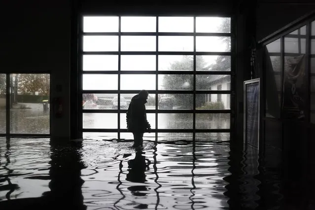 A garage owner walks in his flooded garage in Longfosse, northern France, on November 10, 2023. The Pas-de-Calais region was once again hit by torrential rains, and was placed on red alert for flooding for the second time in a week, with a historic rise in water levels on November 7, 2023. (Photo by Sameer Al-Doumy/AFP Photo)