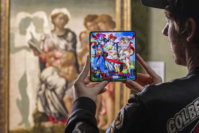 Philip Colbert, a pop artist, on November 20, 2023 uses a OnePlus phone to complete his take on The Madonna and Child with St John and Angels, also known as the Manchester Madonna, an unfinished painting by Michelangelo in the National Gallery in United Kingdom. (Photo by David Parry/PA Wire Press Association)