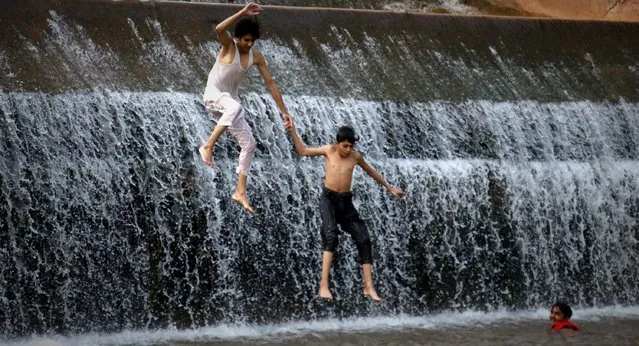 Pakistani boys cool off in the waters of the Simli dam as heat wave continues in Islamabad, Pakistan, 25 August 2021. Pakistan's Meteorological Department (PMD) said the weather in the city will remain hot and humid for the next days. (Photo by Sohail Shahzad/EPA/EFE)