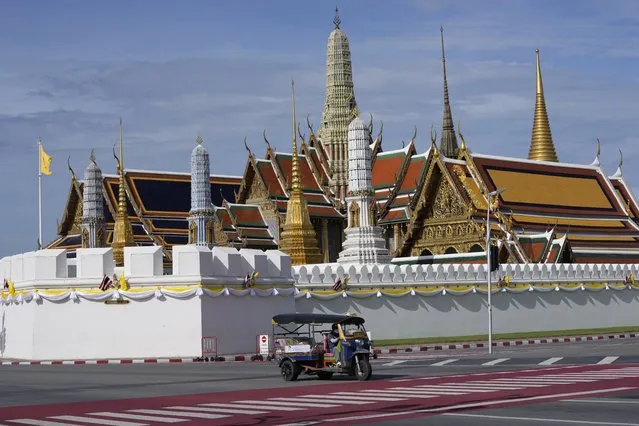 A motor-tricycle, or Tuk Tuk drives past Grand Palace in Bangkok, Thailand on August 3, 2021. As Thailand battles a punishing COVID-19 surge with nearly 20,000 new cases every day, people who depend on tourism struggle in what was one of the most-visited cities in the world, with 20 million visitors in the year before the pandemic. (Photo by Sakchai Lalit/AP Photo)