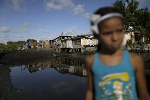 A child is seen in front of stilt houses at a lake dwelling also known as palafitte or “Palafito” in Recife, Brazil, March 1, 2016. (Photo by Ueslei Marcelino/Reuters)
