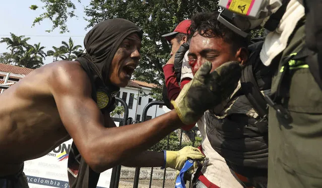 A youth, right, who was injured in clashes with Venezuelan National Guardsmen, who are blocking the entry of U.S.-supplied humanitarian aid on the Simon Bolivar International Bridge, is carried by medics to a safe zone in La Parada, Colombia, Monday, February 25, 2019, on the border with Venezuela. The delivery of humanitarian aid to the economically devastated nation has faltered amid strong resistance from security forces who remain loyal to Venezuelan President Nicolas Maduro. (Photo by Fernando Vergara/AP Photo)
