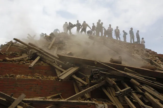 Volunteers help remove debris of a building that collapsed at Durbar Square, after an earthquake in Kathmandu, Nepal, Saturday, April 25, 2015. (Photo by Niranjan Shrestha/AP Photo)