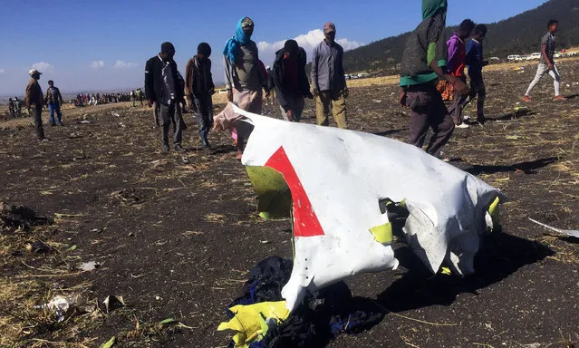 People walk past a part of the wreckage at the scene of the Ethiopian Airlines Flight ET 302 plane crash, near the town of Bishoftu, southeast of Addis Ababa, Ethiopia March 10, 2019. (Photo by Tiksa Negeri/Reuters)